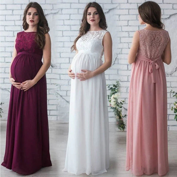 Three pregnant women modeling sleeveless lace maternity dresses in burgundy, white, and pink against white brick wall