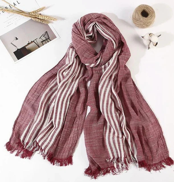 Soft maroon scarf with white vertical stripes and fringed edges on white background