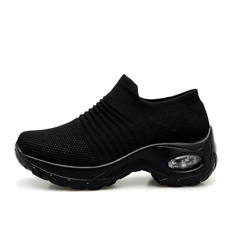 Black slip-on sneaker with knitted upper and thick cushioned sole featuring visible air cushion
