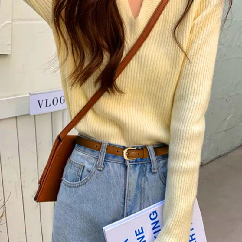 casual outfit with cream ribbed sweater, light blue jeans, brown belt, and brown crossbody bag