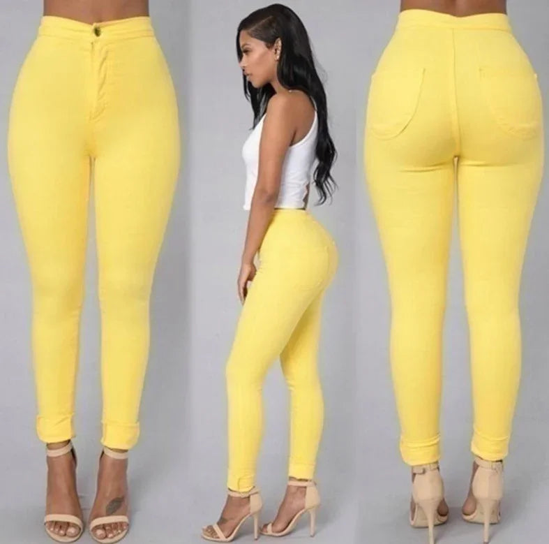 Woman modeling yellow high-waisted skinny jeans with rolled cuffs and beige high heels