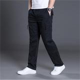 Man wearing casual black cargo pants with white sneakers on gray background