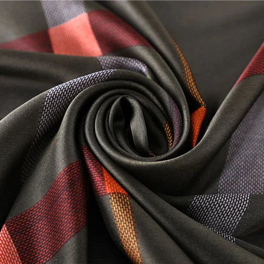 Close-up of soft fabric with dark base and multicolor geometric stripes in red, orange, and gray