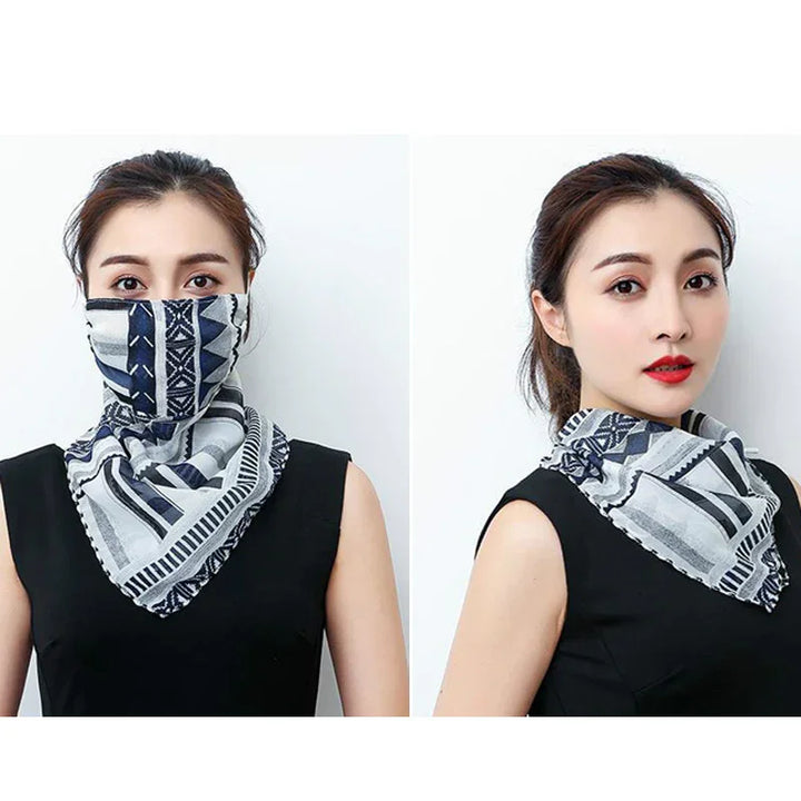 Woman wearing black sleeveless top with patterned black white grey scarf styled as face mask and neck accessory