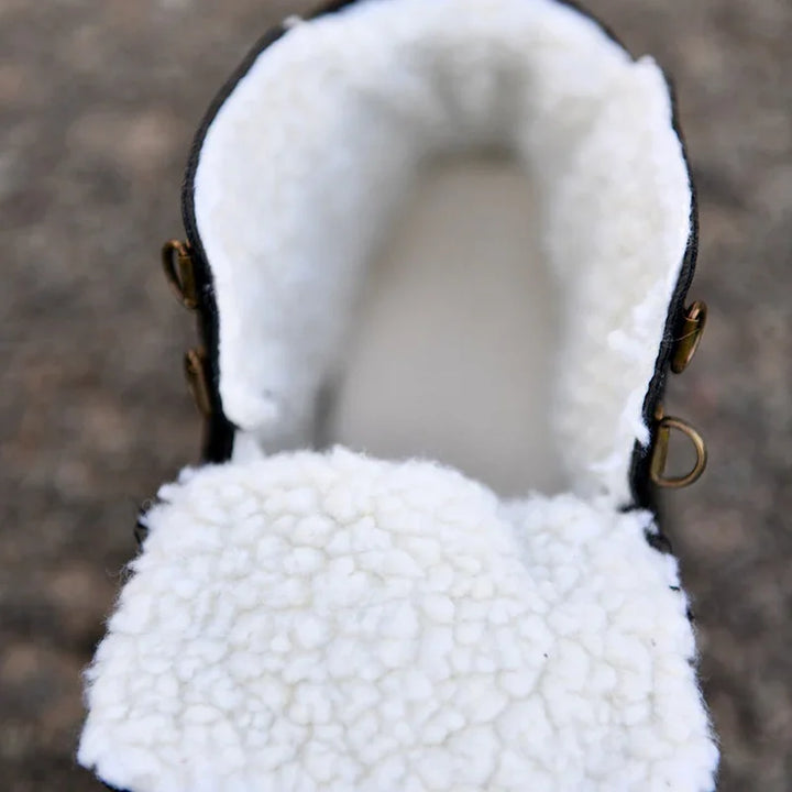 Close-up of white fleece-lined boot interior with black trim and metal eyelets outdoors