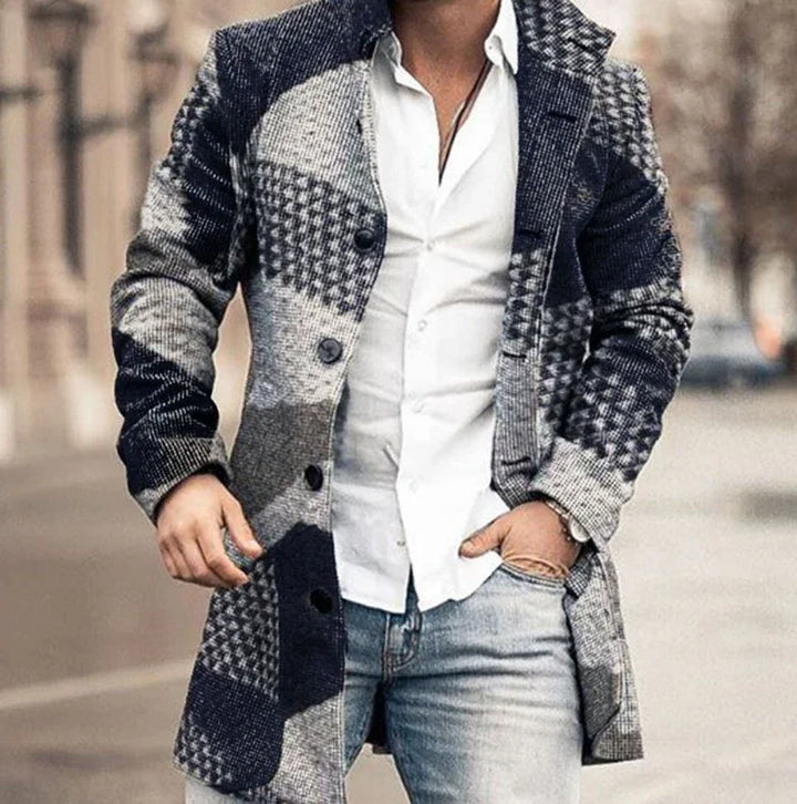 Man wearing a black and grey checkered wool coat over a white button-up shirt and light blue jeans