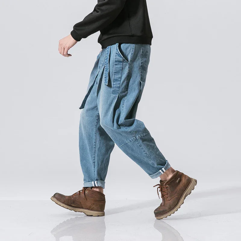 Man walking in light blue cuffed denim pants with straps and brown lace-up boots