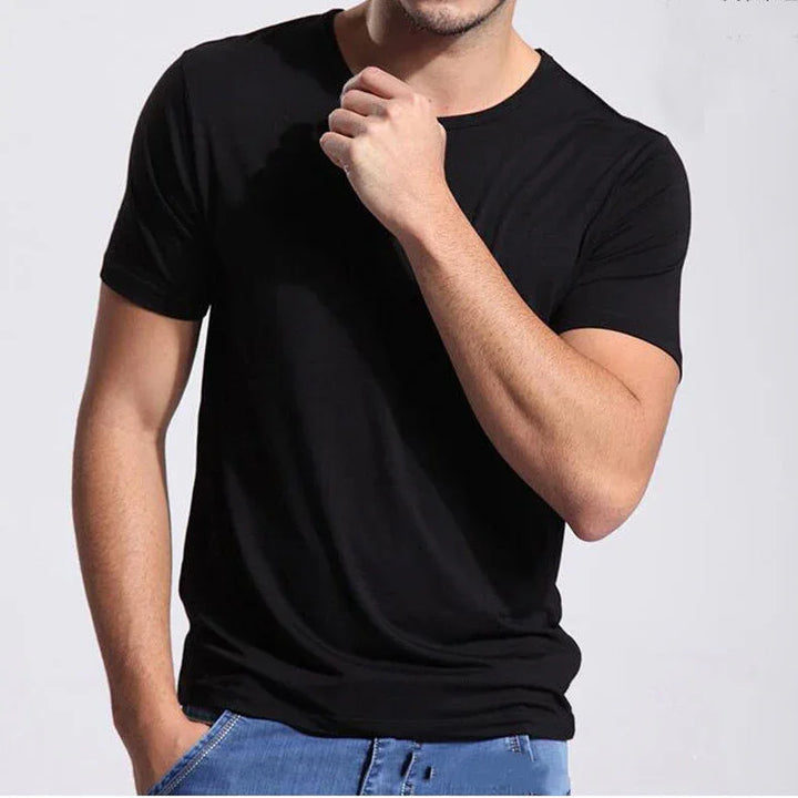 Man wearing plain black short-sleeve t-shirt and blue jeans against gray background