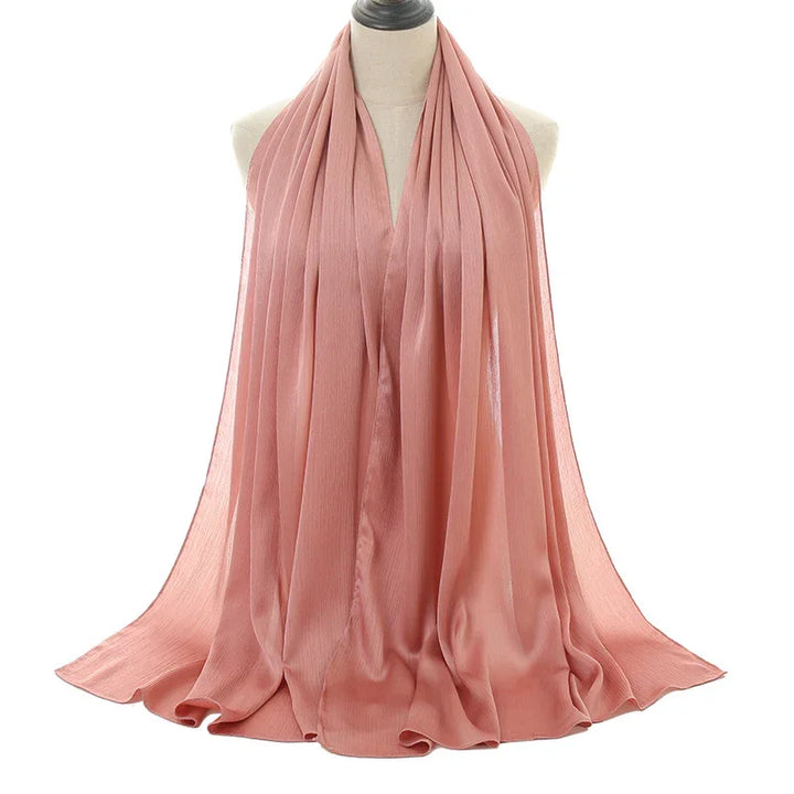 Soft pink pleated chiffon scarf displayed on mannequin against white background