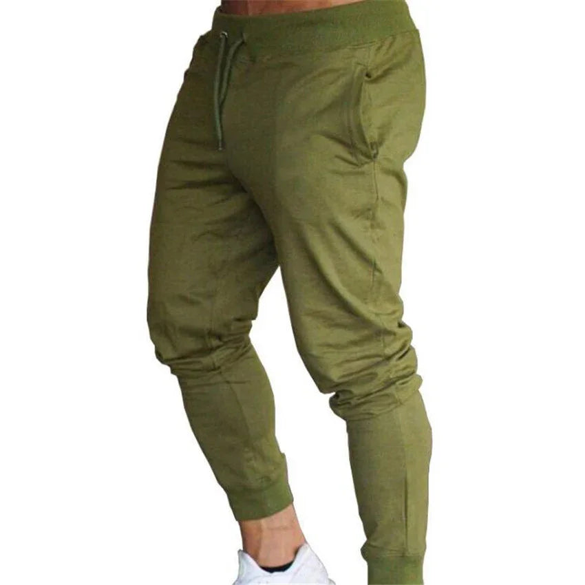 Men's olive green jogger pants with drawstring waist and side pockets, worn with white sneakers