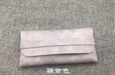Light purple leather eyeglass case on gray fabric background with Chinese text