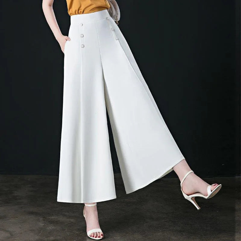 Woman wearing white wide-leg high-waist pants with button details and white strappy heels