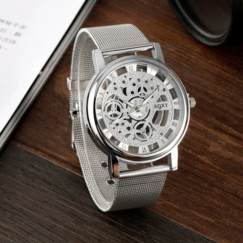 Silver SOXY skeleton watch with mesh strap and visible gears on wooden surface