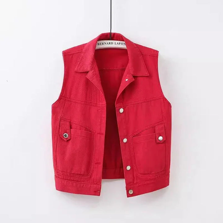 Red sleeveless denim vest with silver buttons and front pockets, hanging on a white background