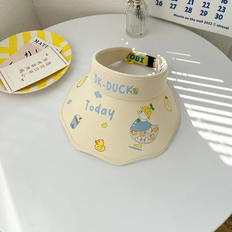 Beige visor hat with cute duck and bubble tea print, text OK-DUCK Today, on white round table
