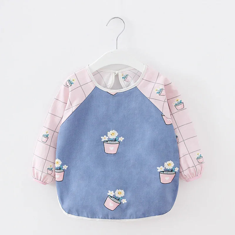 Baby bib with long pink sleeves featuring potted flower print and blue front panel with matching flower pots