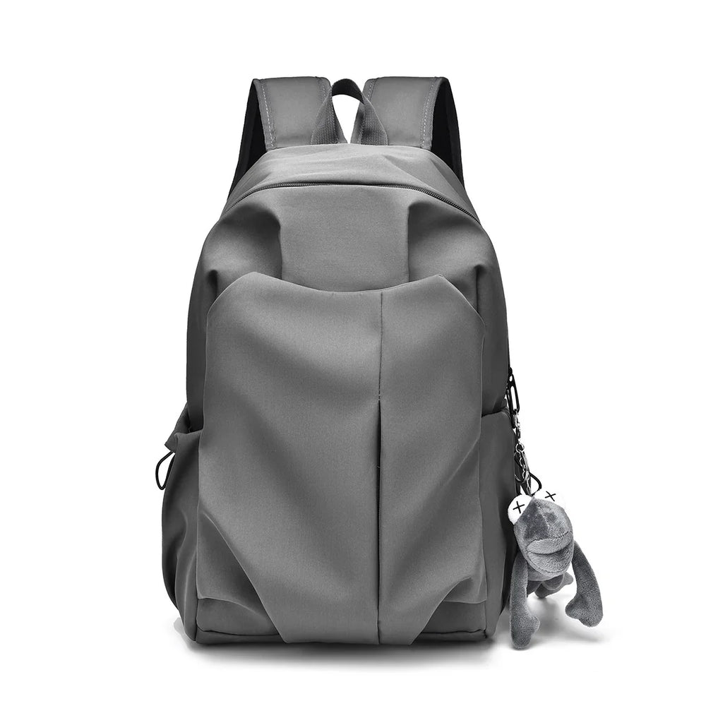 Gray stylish backpack with front pocket and plush keychain on white background