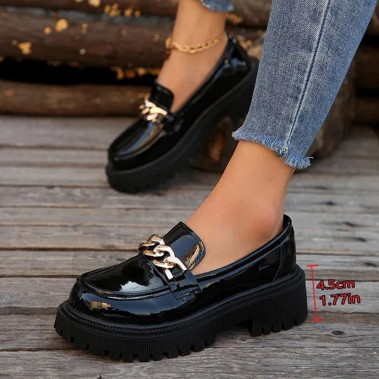 Black patent leather chunky heel loafers with gold chain detail and 4.5 cm platform worn with frayed hem jeans
