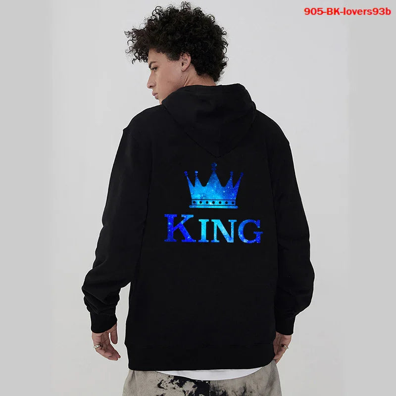 Man wearing black hoodie with blue crown and King text graphic on back in casual studio setting