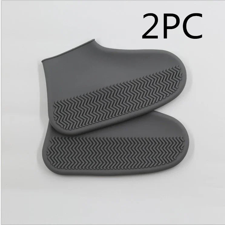 Pair of gray waterproof shoe covers with textured anti-slip soles on white background