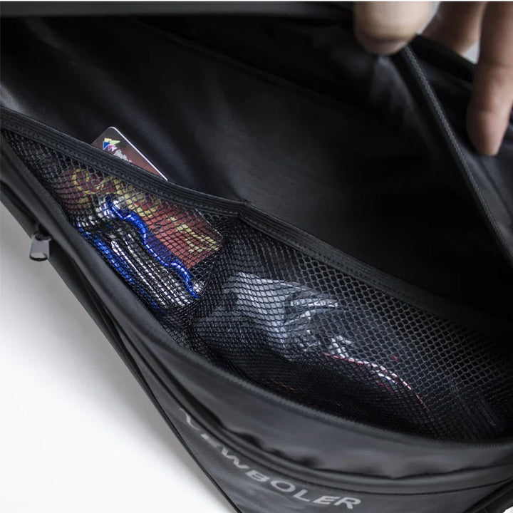 Close-up of mesh pocket inside black NEWBOLER backpack with small items and cards visible