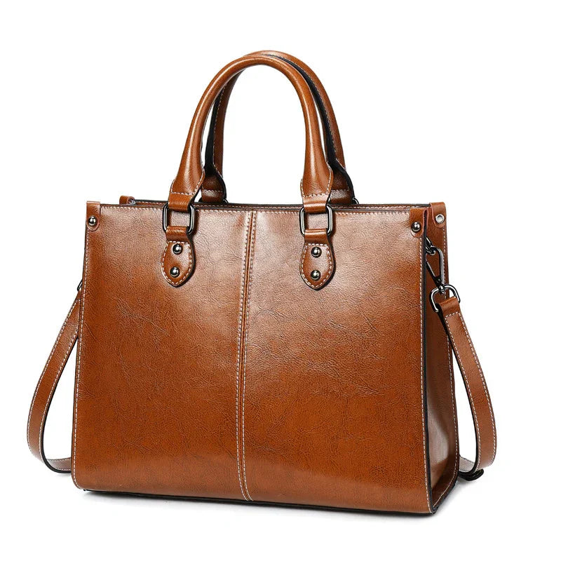 Brown leather handbag with double handles and detachable shoulder strap on white background