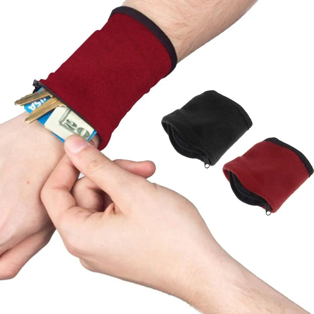 Red wrist wallet pouch holding cash and cards, with black and red zippered wristbands nearby.