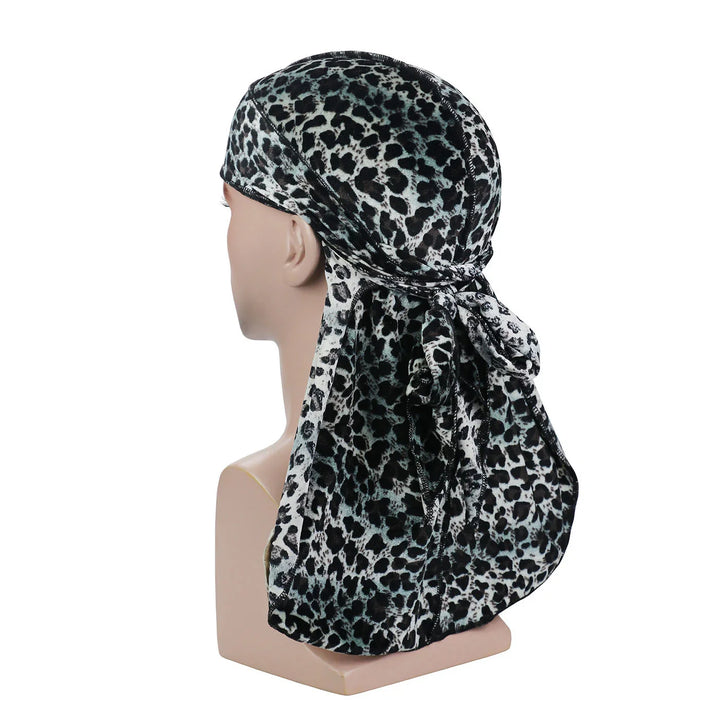 Mannequin head wearing black and white leopard print durag with long tieback on white background