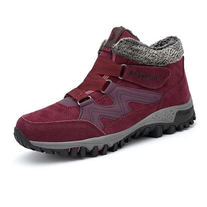 Maroon winter hiking boot with fur lining, thick sole, and strap closure on white background