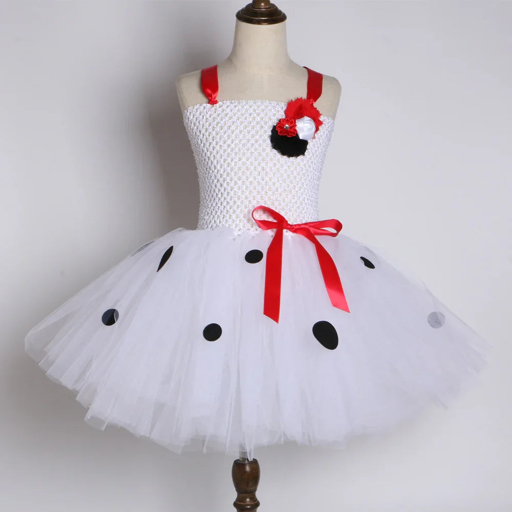 White toddler tutu dress with black polka dots, red ribbon straps and bow, displayed on mannequin