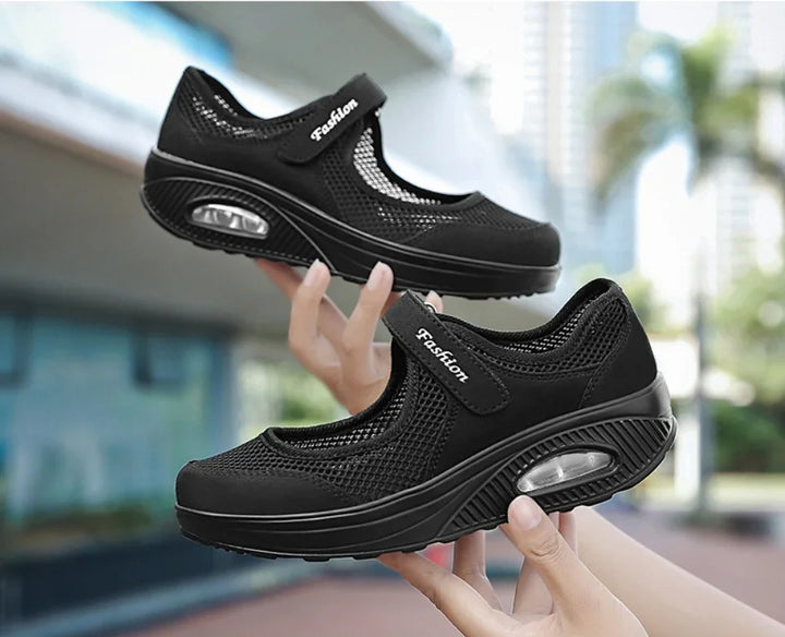 Black mesh Mary Jane platform shoes with air cushion sole held outdoors