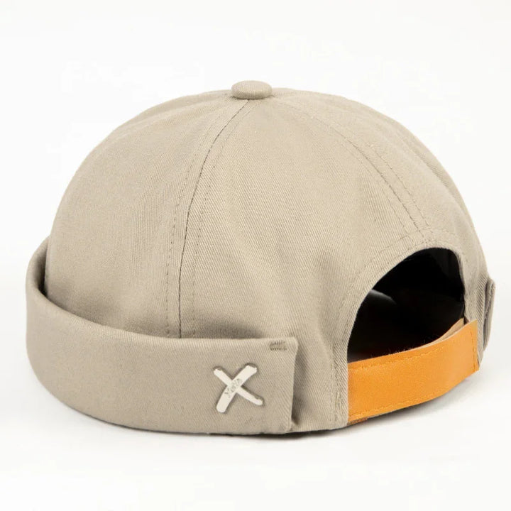 Beige canvas cap with rolled brim and adjustable tan strap, simple modern design