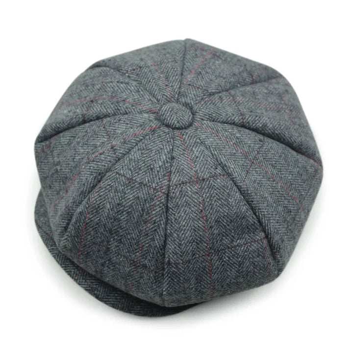 Gray tweed newsboy cap with herringbone pattern and subtle red lines on white background