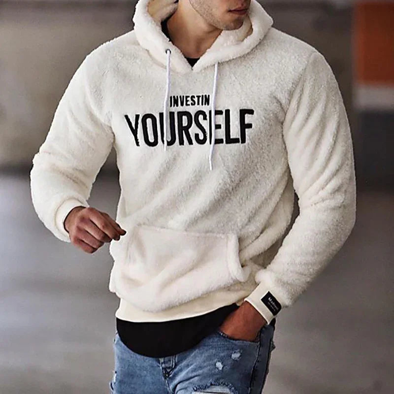Man wearing white fluffy hoodie with INVEST IN YOURSELF text, paired with ripped jeans