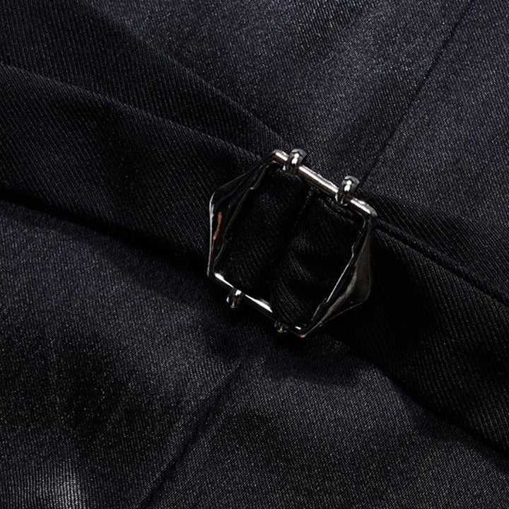 Close-up of black fabric with a silver-toned rectangular buckle detail