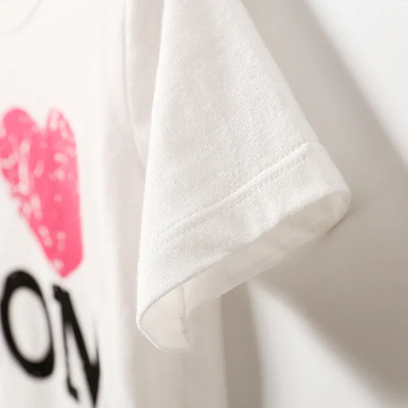 Close-up of white T-shirt sleeve with partial pink heart and black love text print