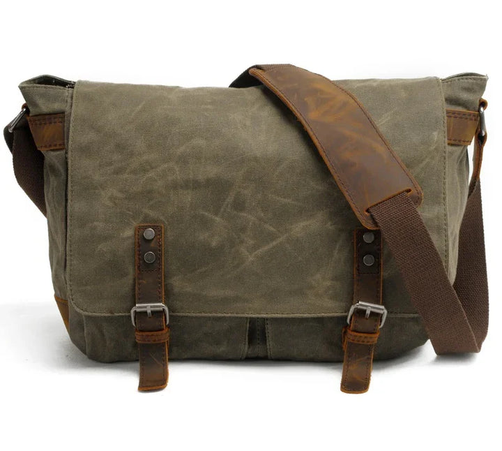 green canvas messenger bag with brown leather straps and adjustable shoulder strap