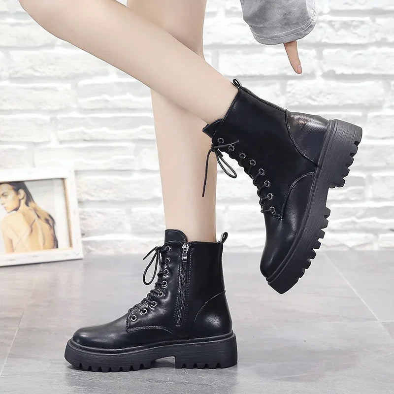Stylish black leather combat boots with chunky soles worn indoors on tiled floor