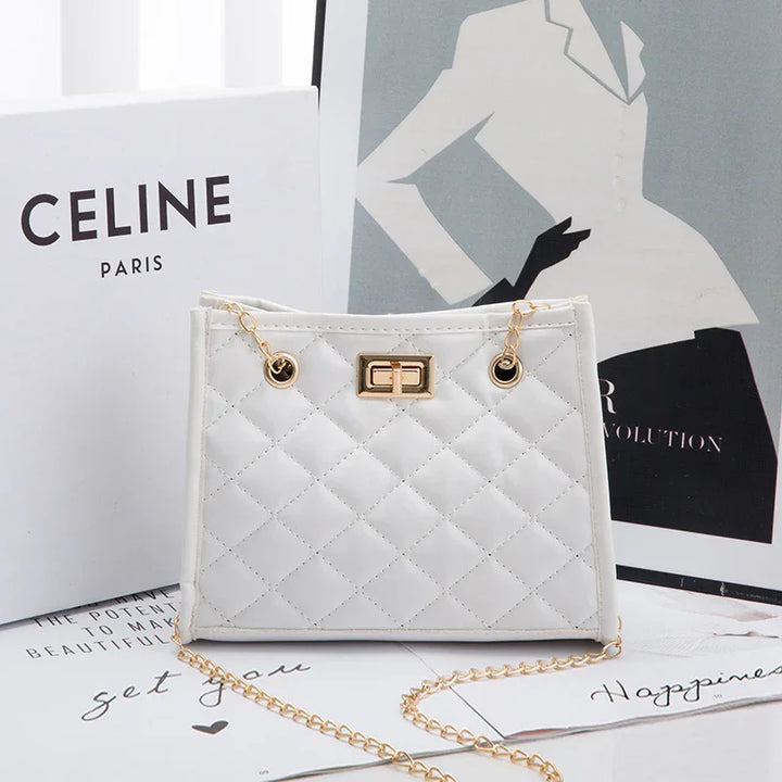 White quilted handbag with gold chain strap and clasp, styled with Celine Paris box and fashion art