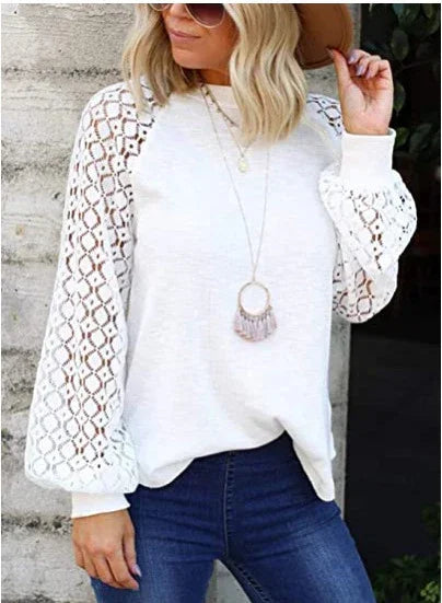 Woman wearing white long sleeve top with crochet lace balloon sleeves and blue jeans