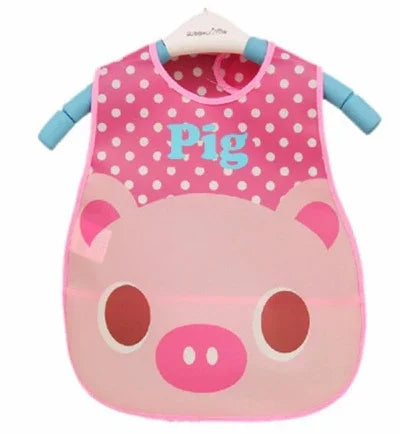 Pink baby bib with white polka dots, pig face design, and blue text 'Pig' on front