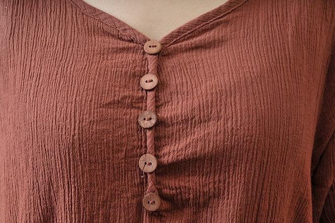 close-up of brown textured fabric top with five matching buttons and v-neck design