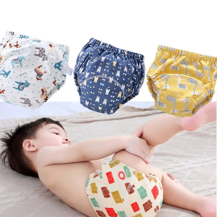 Baby lying down wearing colorful printed reusable cloth diaper with three additional printed diapers above