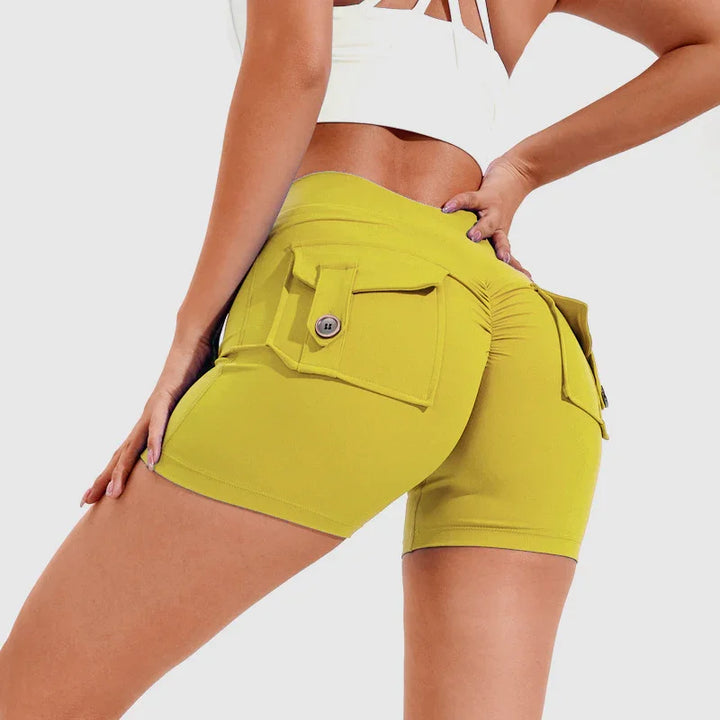Woman wearing yellow high-waisted shorts with buttoned back pockets and ruched detail