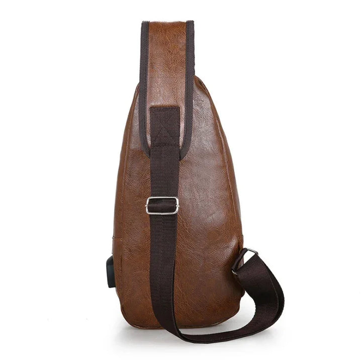 Brown leather sling backpack with adjustable dark brown strap and metal buckle on white background