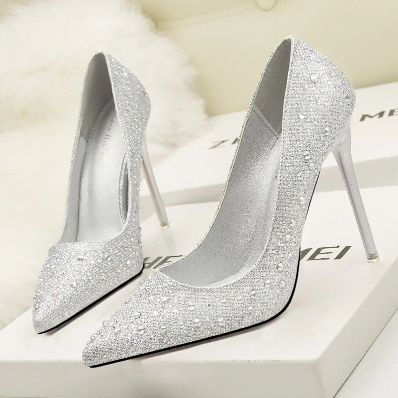 Elegant silver high heel stiletto shoes embellished with rhinestones and pearls on white boxes