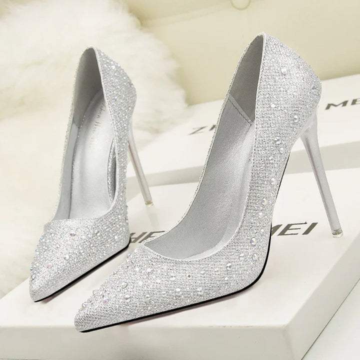 Elegant silver high heel stiletto shoes embellished with rhinestones and pearls on white boxes