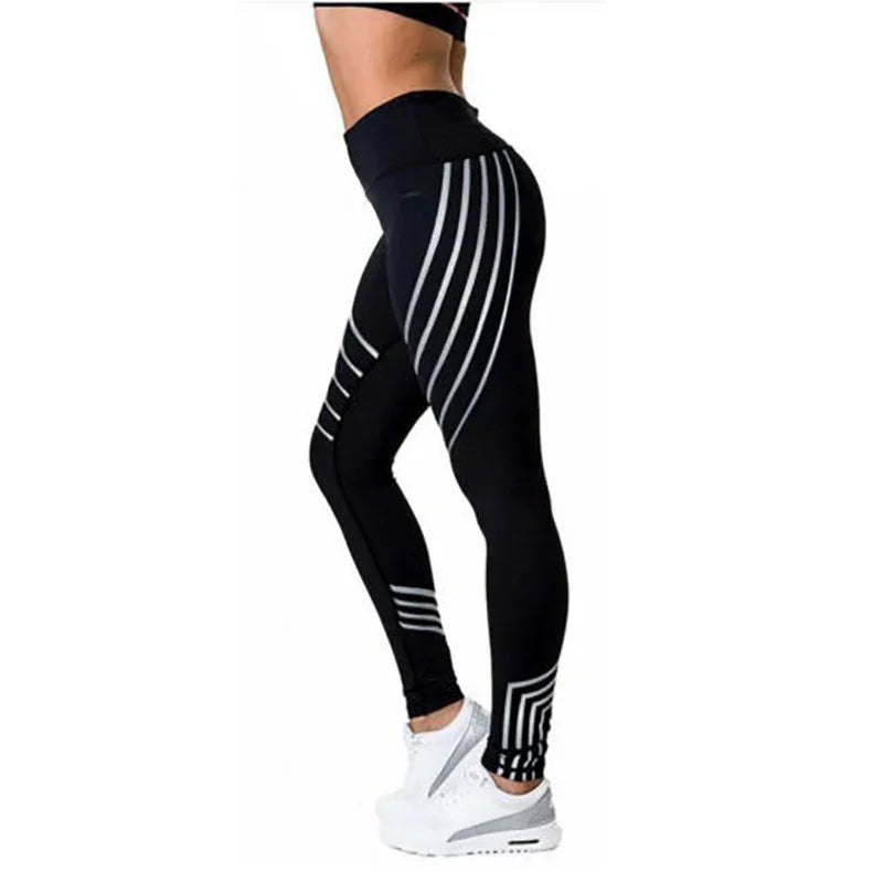 Side view of a person wearing black high-waisted leggings with white geometric stripes and white sneakers