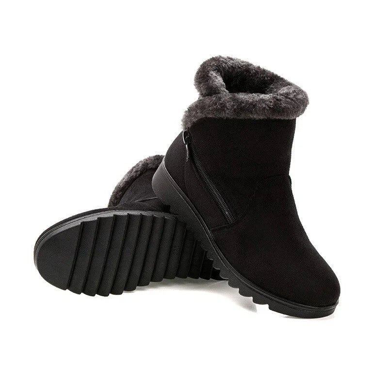 Black winter boots with plush gray fur lining and side zipper on white background