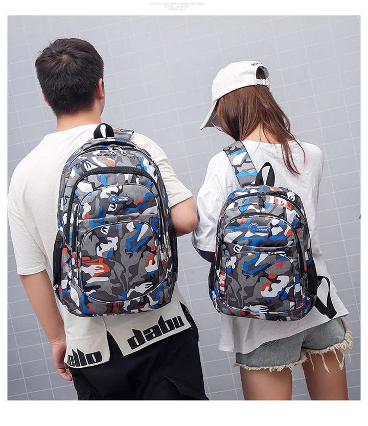 Man and woman wearing matching blue gray orange camouflage backpacks against gray tiled wall